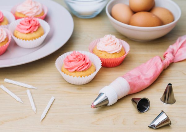 cotton-icing-bag-with-nozzle-cupcake-eggs-candles-wooden-desk
